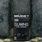 GUMING Energy Koffein Kaugummi mit Guarana und Vitaminen in Geschmacksrichtung Blacker The Berry auf Betonboden mit einzelnen Kaugummis drum herum